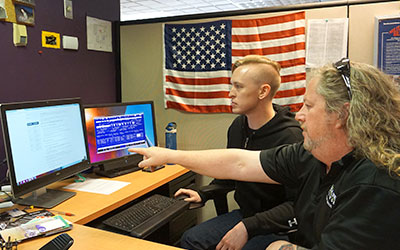 Veterans Services Representative pointing at computer screen